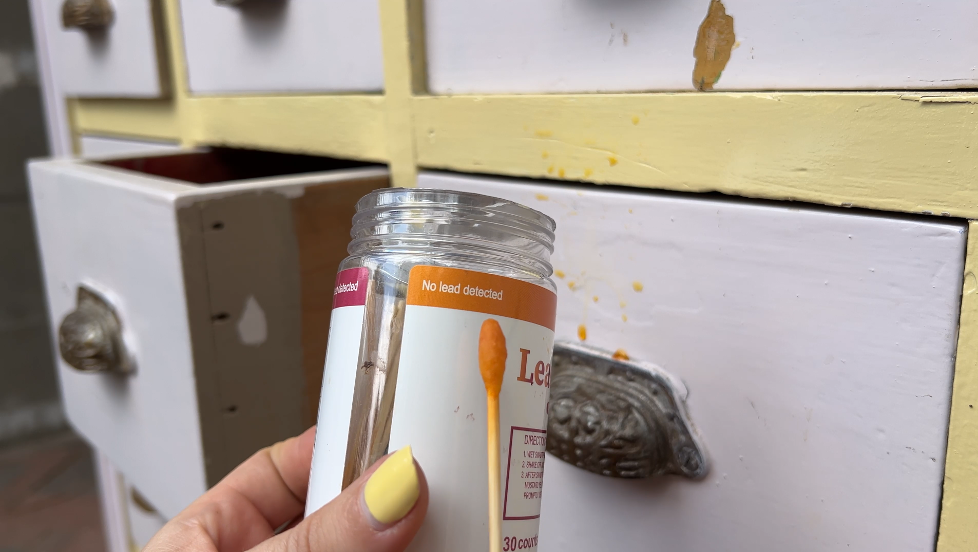 Bij het uit elkaar halen van de kast kwam ik laag na laag tegen: geel, grijs, groen en zelfs rood. Het vergde meerdere lagen afbijtmiddel en eindeloos veel schrapen. Het voelde alsof ik mijn geld verloren had aan een nep-antik.
Maar bij de laden gebeurde er iets bijzonders… De kast was eerder omgebouwd tot een lollypop-stand en zat vol met toevoegingen. Eerst haalde ik alle losse delen, felle verf en MDF-platen weg. Let altijd op bij dit soort projecten: vaak zijn originele elementen verborgen onder latere toevoegingen.