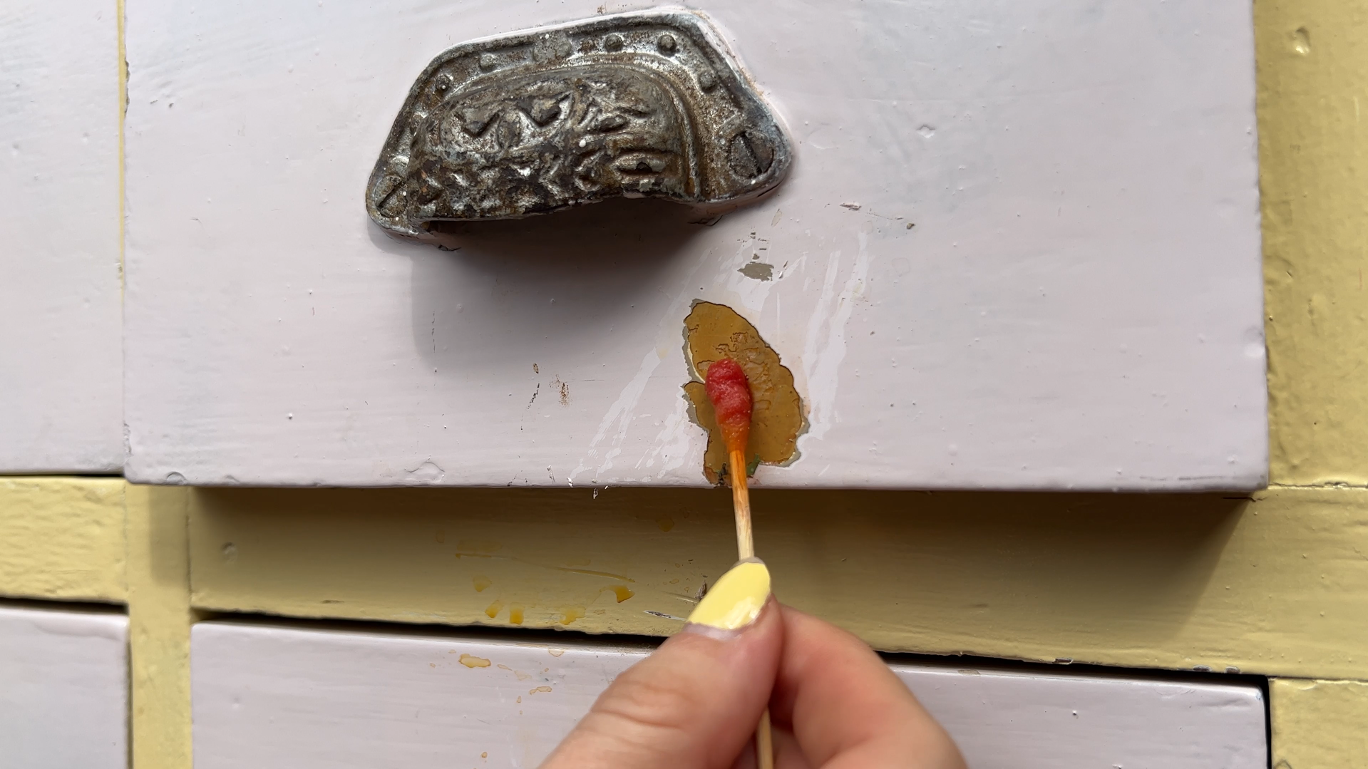 Bij het uit elkaar halen van de kast kwam ik laag na laag tegen: geel, grijs, groen en zelfs rood. Het vergde meerdere lagen afbijtmiddel en eindeloos veel schrapen. Het voelde alsof ik mijn geld verloren had aan een nep-antik.
Maar bij de laden gebeurde er iets bijzonders… De kast was eerder omgebouwd tot een lollypop-stand en zat vol met toevoegingen. Eerst haalde ik alle losse delen, felle verf en MDF-platen weg. Let altijd op bij dit soort projecten: vaak zijn originele elementen verborgen onder latere toevoegingen.